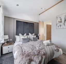 A bedroom with a bed and bedside table at Atlantic Breeze Luxury Lodge sleep 6 near Mullacott