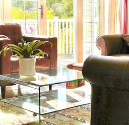 A living room with a glass table and brown armchair at Stunning Sleeps 6 Luxury Lodge Pets Mercia Marina near Willington, Derbyshire