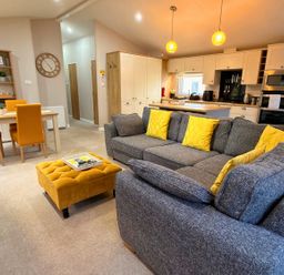 A living room with a sofa and dining table at Meadows 33 Hot tub Southview Holiday Park Skegness