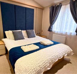A bedroom with a bed and pillows at Meadows 33 Hot tub Southview Holiday Park in Skegness