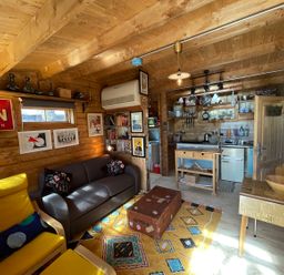 A living room with a sofa and kitchen area at the property