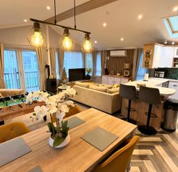 A living room with a sofa, dining area, kitchen counter and foosball table at the property in location