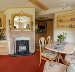 A dining room with a fireplace and table at Leven in Lampeter