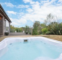 An outdoor area with a hot tub near a wooden deck at 5 Tree Tops in Dobwalls