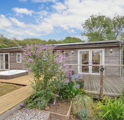 An outdoor area with a hot tub and wooden building at 5 Tree Tops in Dobwalls