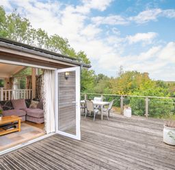 A deck area with a couch and outdoor dining table at 5 Tree Tops in Dobwalls