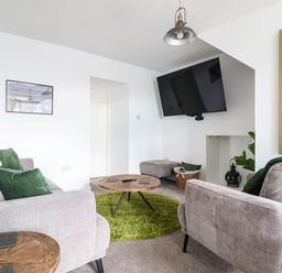 A living room with a sofa, coffee table, and television at 1 Glanaber Terrace