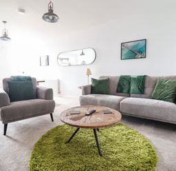 A living room with a sofa, armchair, and coffee table at 1 Glanaber Terrace