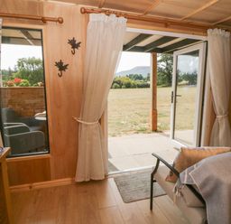 A living room with a view of a patio and garden at Oak Lodge in Brecon