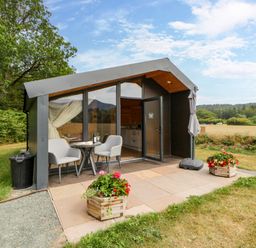 A small cabin with outdoor seating at Sycamore Lodge Brecon