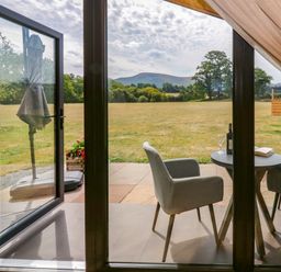 A table with chairs and a wine bottle at Sycamore Lodge Brecon