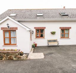 A home exterior with windows, a door, and a bench at The Stable in Haverfordwest