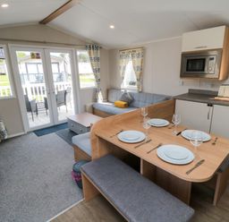 A living room with a dining table and sofa at 14 Pines Cayton Bay