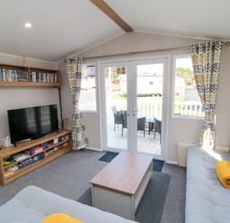 A living room with a television and a coffee table at 14 Pines in Cayton Bay
