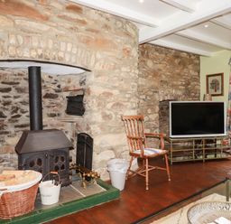 A living room with a wooden stove and television at The Homestead in 