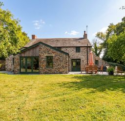 A house with garden furniture and trees at The Homestead in 