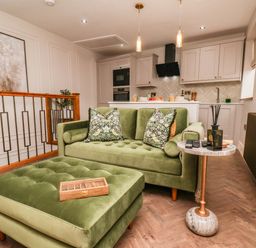 A living room with a green sofa and coffee table at 14 Brunswick Street Whitby