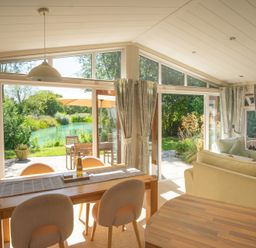 A living room with a view of a river at Ash Lodge in Stowmarket