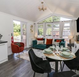 A living room with a sofa and dining area at 73 Cildraeth in New Quay