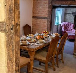 A dining room with a table set for a meal at a property