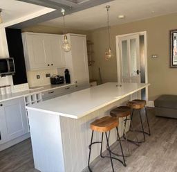 A kitchen with a counter and bar stools at The Old Barn in Manchester