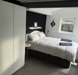 A bedroom with a bed and wardrobe at The Old Barn in Manchester