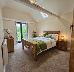 A bedroom with a bed and nightstands at Lily's Cottage Suffolk Sleeps 2 with Pets in Mendlesham Green near Stowmarket