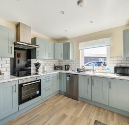 A kitchen with appliances including fridge and oven at Seaside Chalet Retreat in Bridlington