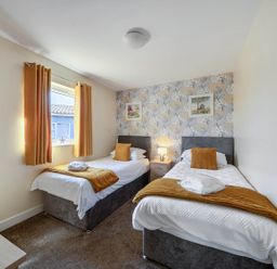 A bedroom with twin beds and a nightstand at Seaside Chalet Retreat in Bridlington