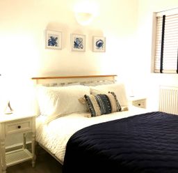 A bedroom with a bed and bedside table at Torpoint Apartment Sleeps4 Seaside Parking in Downderry