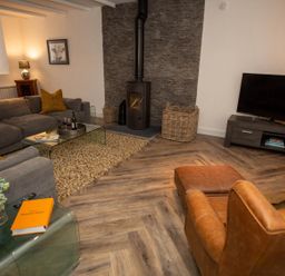 A living room with a sofa and fireplace at Stunning 3 Bed Converted Village Hall Near Kelso in Nenthorn near Kelso