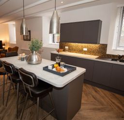 A kitchen with bar stools and countertop at Stunning 3 Bed Converted Village Hall Near Kelso