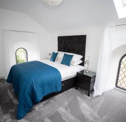 A bedroom with a bed and window at Stunning 3 Bed Converted Village Hall Near Kelso Nenthorn near Kelso