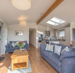 A living room with sofas, a coffee table, and a kitchen area at 2 Bedroom Sleeps 4 Lodge Smart Tv Hot tub Dogs Ok near Lochwinnoch