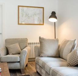 A living room with a sofa and armchair at 2 bedroom lodge with free WiFi and mountain view near Crianlarich