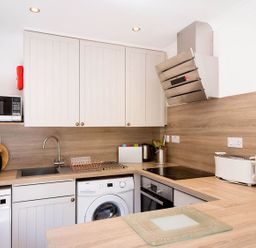 A kitchen with microwave and washing machine at 2 bedroom lodge with free WiFi and mountain view near Crianlarich