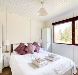 A bedroom with a bed and wardrobe at 2 bedroom lodge with free WiFi and mountain view near Crianlarich