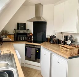 A kitchen with appliances and cabinetry at Central Tenby 3 Bed Apt Sleeps 6 to 8 Dog Friendly in Tenby