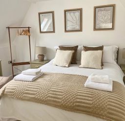 A bedroom with a bed, bedside tables, and artwork at Central Tenby 3 Bed Apt Sleeps 6 to 8 Dog Friendly, Tenby