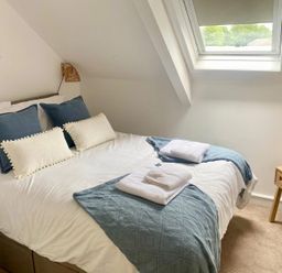 A bedroom with a bed and mirror at Central Tenby 3 Bed Apt Sleeps 6 to 8 Dog Friendly in Tenby