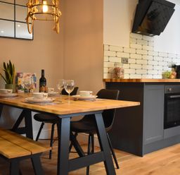 A dining room with a wooden table and chairs at Yr Hen Beudy Barn Conversion Sleeps 4 Dogs Ok near Brodle Farm near Llansteffan