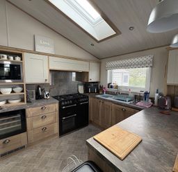 A kitchen with modern appliances at Harrogate Lodge Sleeps4 South Facing Decking Lufflands Caravan Park near Holsworthy