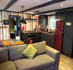 A living room with a kitchen area and a sofa at Sandy Balls Holiday Park Pet Friendly Lodge in Godshill, Hampshire