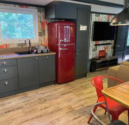 A kitchen with a refrigerator and a dining table at Sandy Balls Holiday Park Pet Friendly Lodge in Godshill, Hampshire