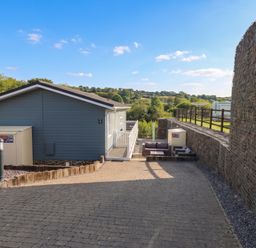 An outdoor area with a lodge and seating at Pleasant Valley Holiday Lodge 70 Stepaside