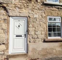 A door and window on a stone wall at Blue Cottage in Malton
