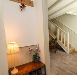 A hallway with a lamp and table at Blue Cottage in Malton