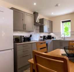 A kitchen with appliances and dining area at Bay Bungalow