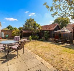 A garden with a table and chairs at The Mill House Apartment