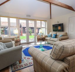 A living room with sofas and a coffee table at The Mill House Annexe Oulton Broad